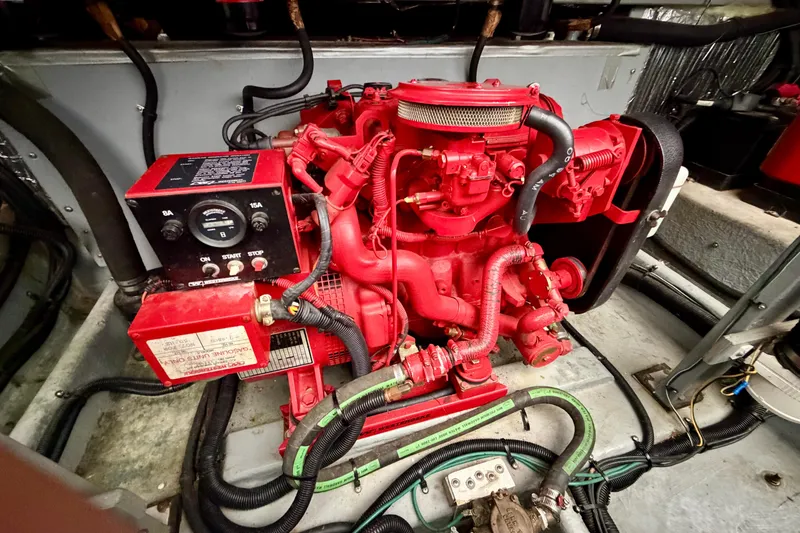 Slide: The Image of Engine compartment of a 1995 Sea Ray 380 Sun Sport, featuring a red engine and control panel. - 19
