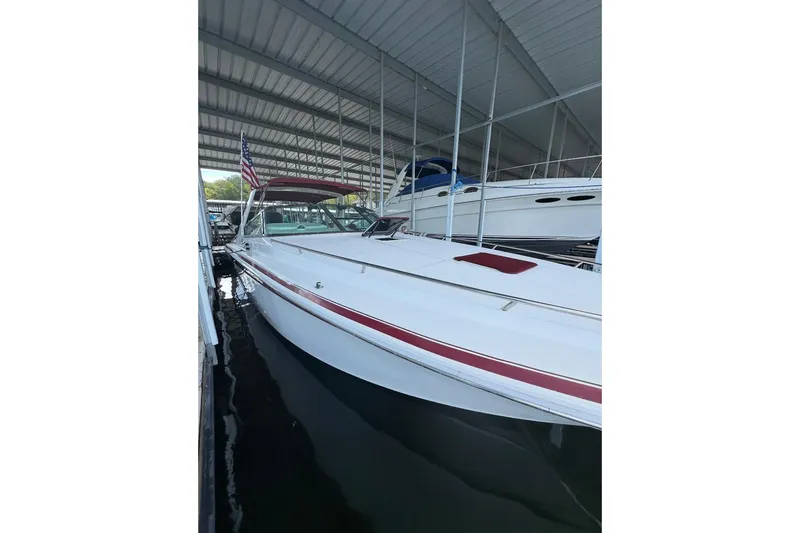 Slide: The Image of 1995 Sea Ray 380 Sun Sport boat docked under a covered marina. - 2
