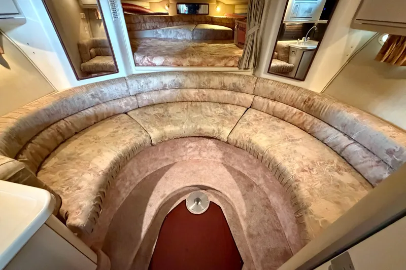 Slide: The Image of 1995 Sea Ray 380 Sun Sport interior with curved seating and cozy cabin design. - 26