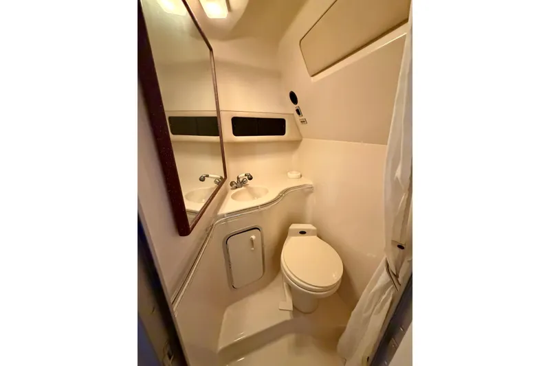 Slide: The Image of Compact bathroom in 1995 Sea Ray 380 Sun Sport boat, featuring toilet and sink. - 30