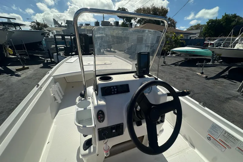 Slide: The Image of 2015 Mako Pro Skiff 17 CC boat interior with steering wheel and control panel. - 11