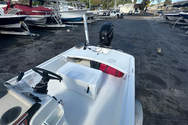 Slide: The Image of 2015 Mako Pro Skiff 17 CC boat at a marina with other vessels. - 13