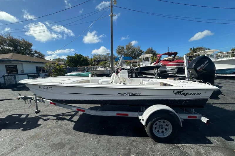 Slide: The Image of 2015 Mako Pro Skiff 17 CC boat on trailer under clear blue sky. - 5