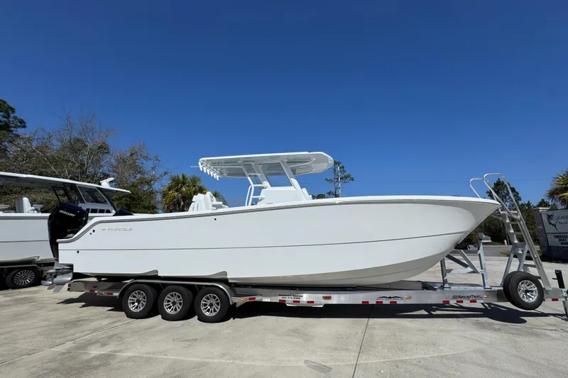 Slide: The Image of 2026 Invincible 33 Catamaran on trailer under clear blue sky. - 10