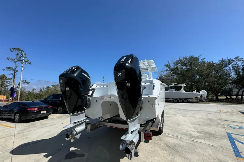 Slide: The Image of 2026 Invincible 33 Catamaran with dual outboard engines in a parking lot. - 14