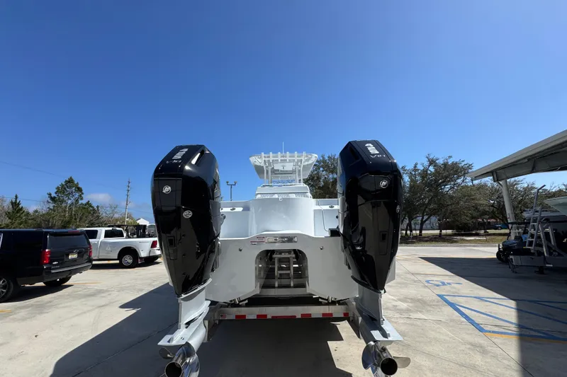 Slide: The Image of 2026 Invincible 33 Catamaran with dual outboard engines, parked outdoors under clear sky. - 15