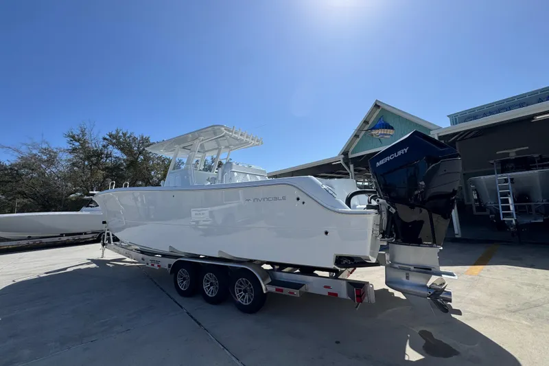 Slide: The Image of 2026 Invincible 33 Catamaran on trailer, featuring Mercury outboard engines, parked outdoors. - 18