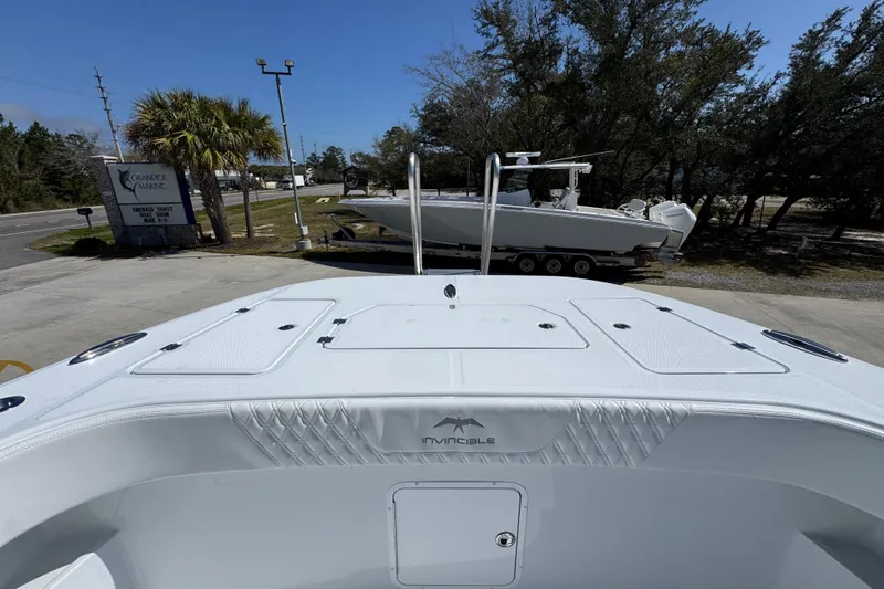Slide: The Image of 2026 Invincible 33 Catamaran at Grander Marine dealership, parked outdoors. - 23