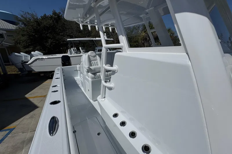 Slide: The Image of 2026 Invincible 33 Catamaran, sleek white design, spacious deck, modern seating, outdoor setting. - 26