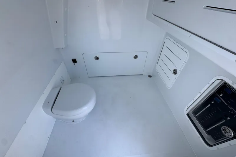 Slide: The Image of Interior of 2026 Invincible 33 Catamaran, featuring a compact marine toilet setup. - 27
