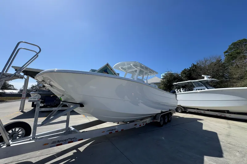Slide: The Image of 2026 Invincible 33 Catamaran on trailer under clear blue sky. - 3