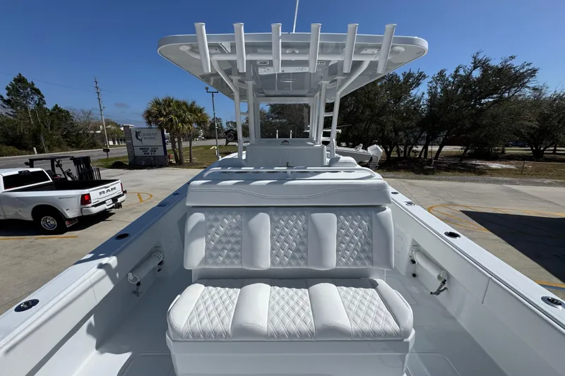 Slide: The Image of 2026 Invincible 33 Catamaran with white seating and T-top, parked outdoors. - 37