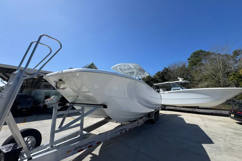 Slide: The Image of 2026 Invincible 33 Catamaran on trailer, parked outdoors under clear blue sky. - 4