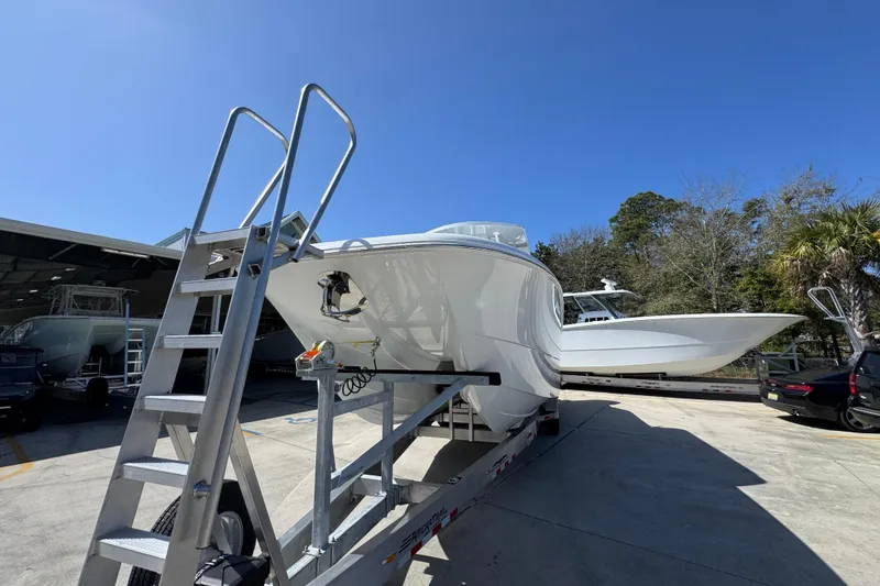 Slide: The Image of 2026 Invincible 33 Catamaran on trailer under clear blue sky. - 5