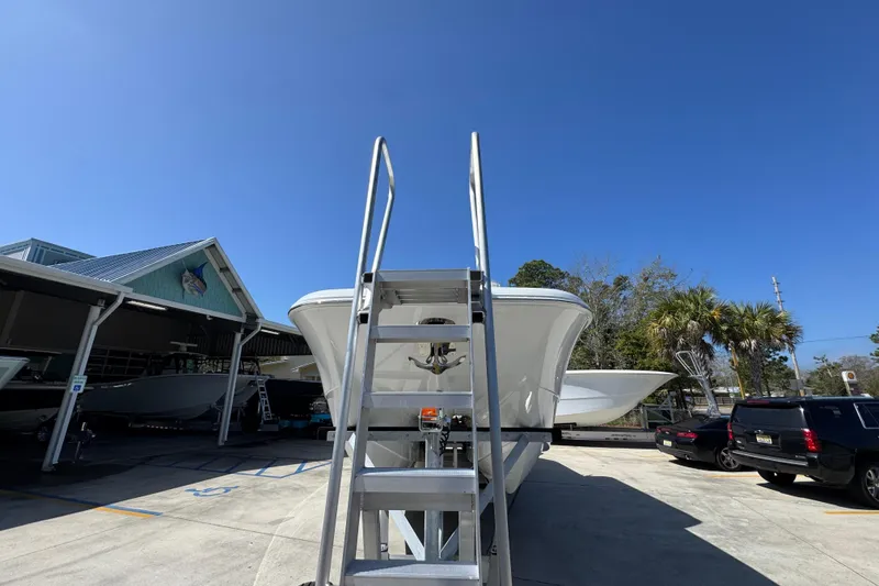 Slide: The Image of 2026 Invincible 33 Catamaran in marina, clear sky, surrounded by vehicles and trees. - 6