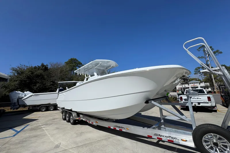 Slide: The Image of 2026 Invincible 33 Catamaran on trailer under clear blue sky. - 8