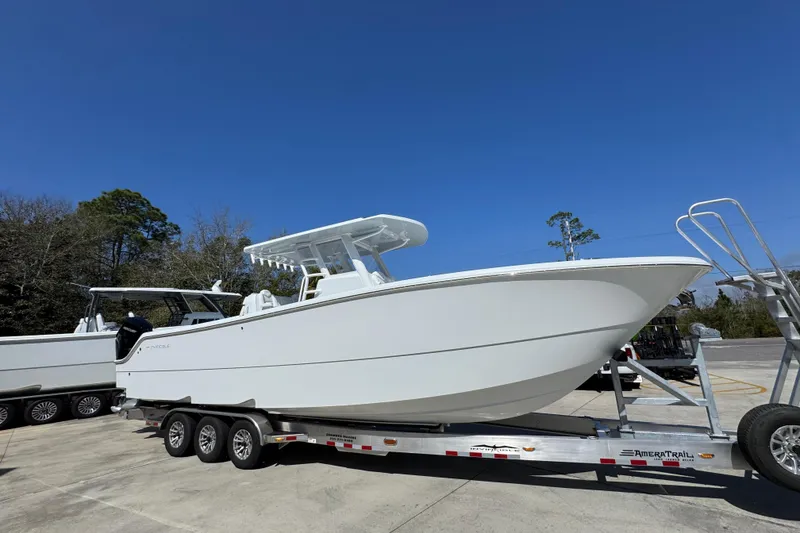 Slide: The Image of 2026 Invincible 33 Catamaran on trailer, parked outdoors under clear blue sky. - 9