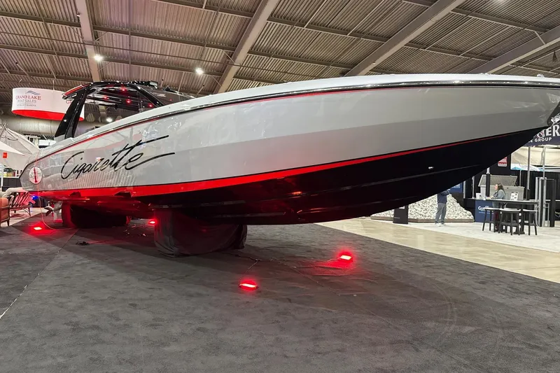 Slide: The Image of 2024 Cigarette 41' Nighthawk SD Edition boat displayed indoors with red lighting. - 17