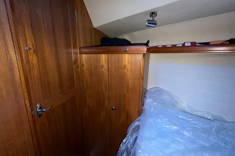 Slide: The Image of Interior cabin of 2005 Hunter 38 sailboat with wooden cabinetry and bedding. - 17