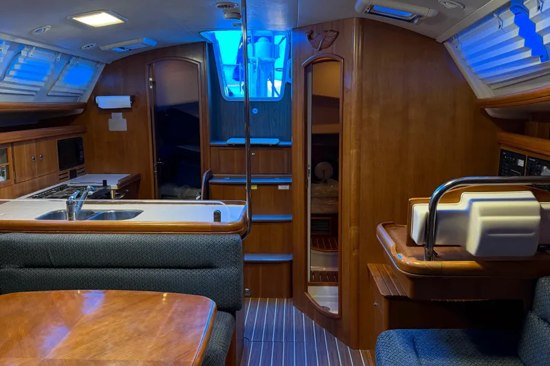 Slide: The Image of Interior of a 2005 Hunter 38 sailboat featuring a cozy kitchen and dining area. - 18