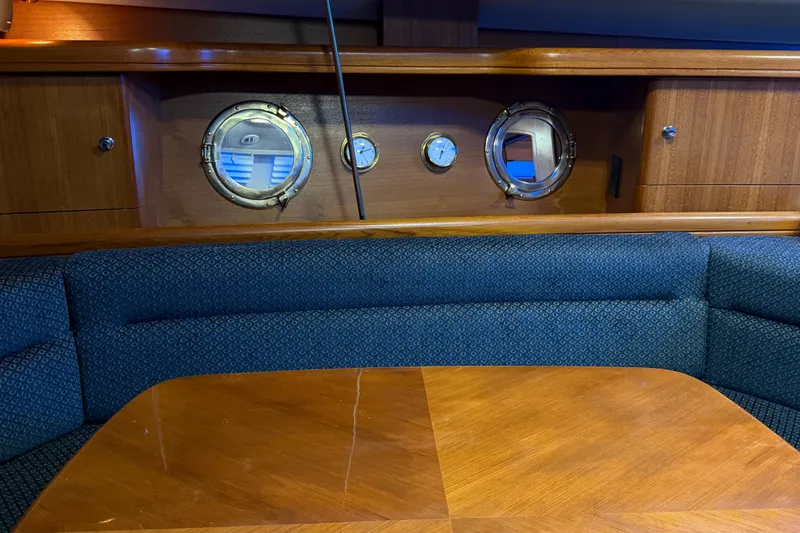 Slide: The Image of Interior of 2005 Hunter 38 yacht with blue seating and wooden table. - 19