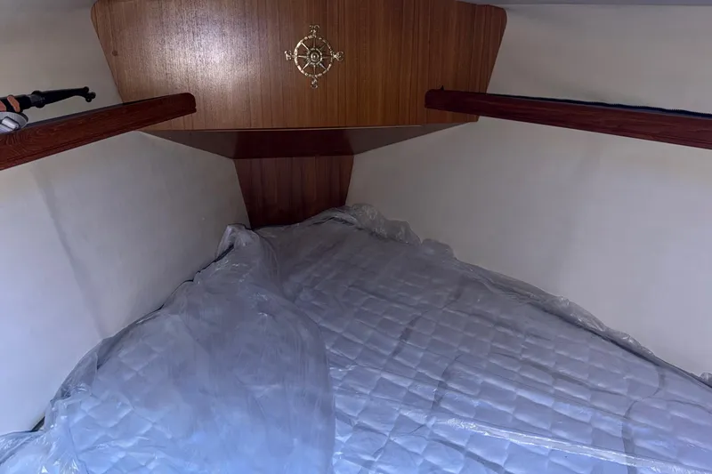 Slide: The Image of Cozy cabin interior of 2005 Hunter 38 sailboat with wooden accents and bedding. - 20