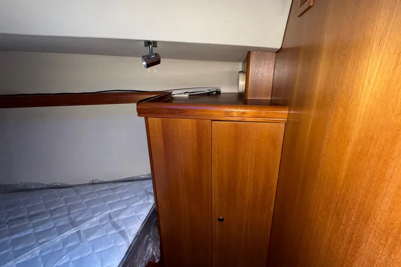 Slide: The Image of Interior cabin of 2005 Hunter 38 sailboat with wooden cabinetry and bed. - 21