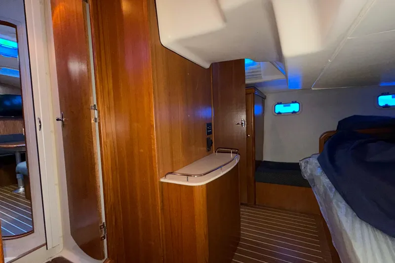 Slide: The Image of 2005 Hunter 38 yacht interior with wooden paneling and cozy sleeping area. - 24