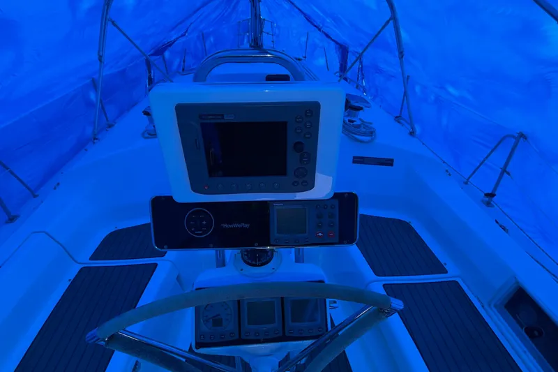 Slide: The Image of Cockpit of 2005 Hunter 38 sailboat under blue tarp, featuring navigation equipment. - 28