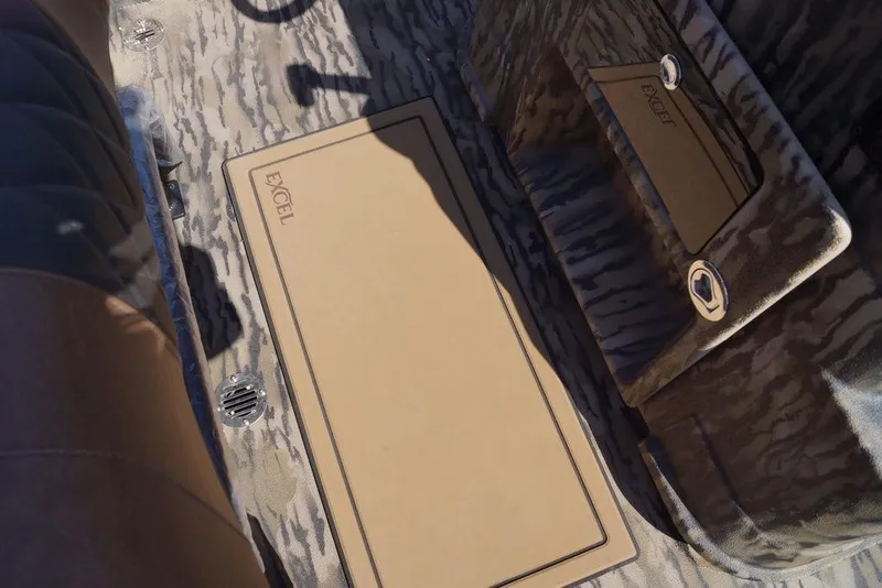 Slide: The Image of 2026 Excel 203 Bay Pro Elite boat interior with camo design and storage compartments. - 14