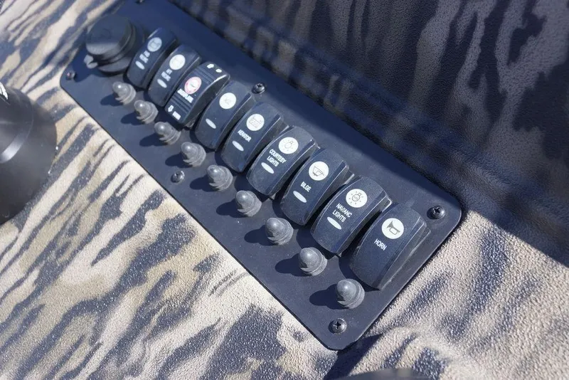 Slide: The Image of Control panel of 2026 Excel 203 Bay Pro Elite boat with various switches. - 16