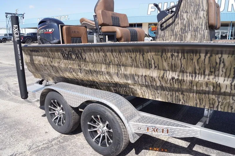 Slide: The Image of 2026 Excel 203 Bay Pro Elite boat on trailer, camo design, parked outdoors. - 19
