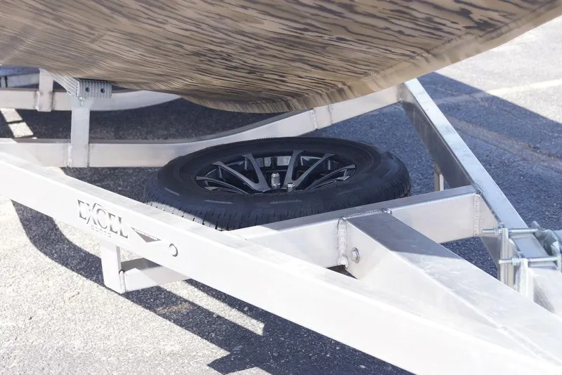 Slide: The Image of 2026 Excel 203 Bay Pro Elite boat trailer with spare tire, parked on asphalt. - 5