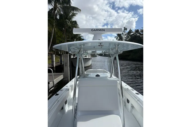 Slide: The Image of 2025 Contender 32 ST boat with Garmin equipment, docked by palm trees and waterway. - 11