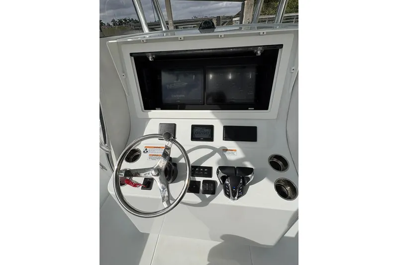 Slide: The Image of 2025 Contender 32 ST boat dashboard with steering wheel and control panel. - 12