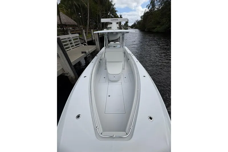 Slide: The Image of 2025 Contender 32 ST boat docked on a calm river, featuring sleek design and Garmin equipment. - 14