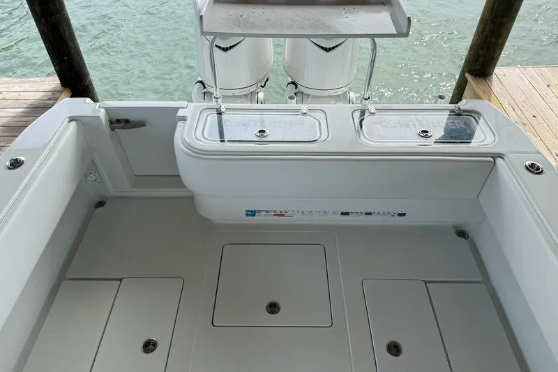 Slide: The Image of 2025 Contender 32 ST boat deck with storage compartments and twin engines. - 24
