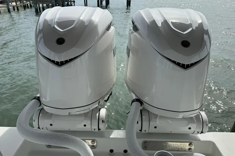Slide: The Image of Twin outboard motors on a 2025 Contender 32 ST boat, docked by the water. - 27