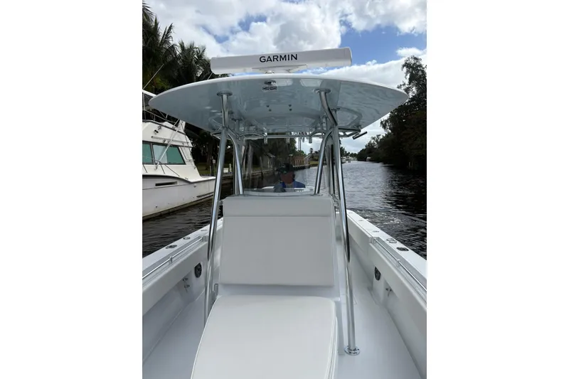 Slide: The Image of 2025 Contender 32 ST boat on a calm waterway, featuring Garmin equipment. - 5