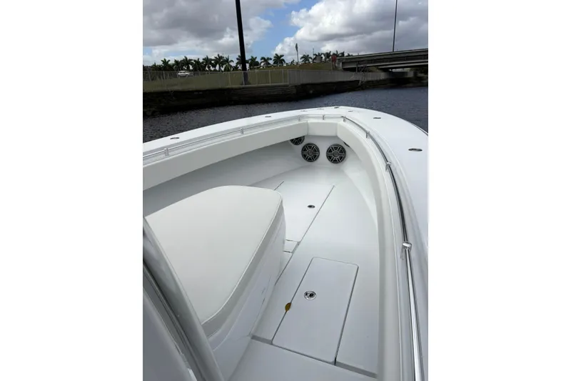 Slide: The Image of 2025 Contender 32 ST boat interior with white seating and speakers, under cloudy sky. - 6