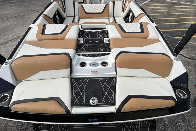 Slide: The Image of 2021 Tigé 25ZX boat interior with tan and white seating, diamond-patterned flooring. - 12