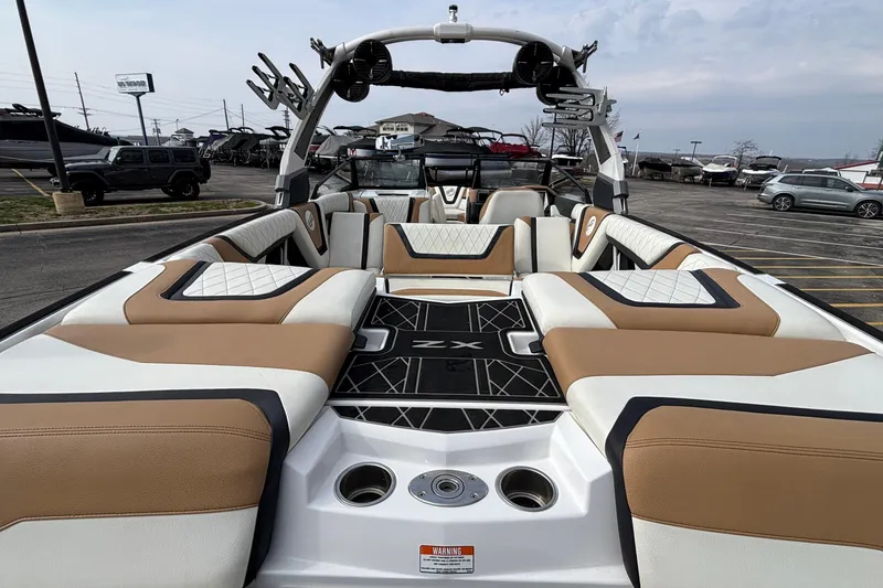 Slide: The Image of 2021 Tigé 25ZX boat interior with luxurious seating and modern design in a parking lot. - 13