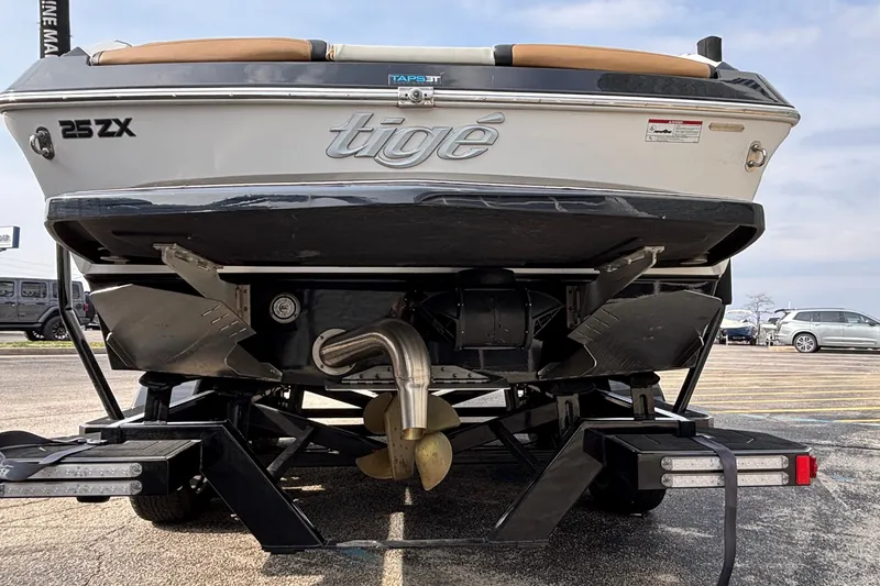 Slide: The Image of 2021 Tigé 25ZX boat on trailer, rear view showing propeller and exhaust system. - 19