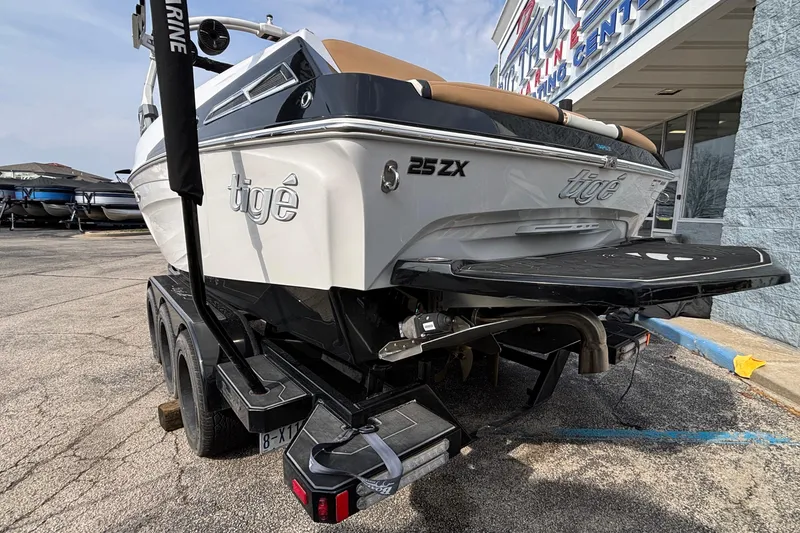 Slide: The Image of 2021 Tigé 25ZX boat on trailer outside marine center. - 21