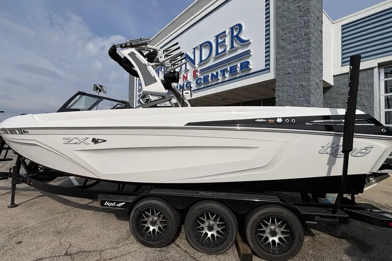 Slide: The Image of 2021 Tigé 25ZX boat on trailer at a marine center, side view. - 22