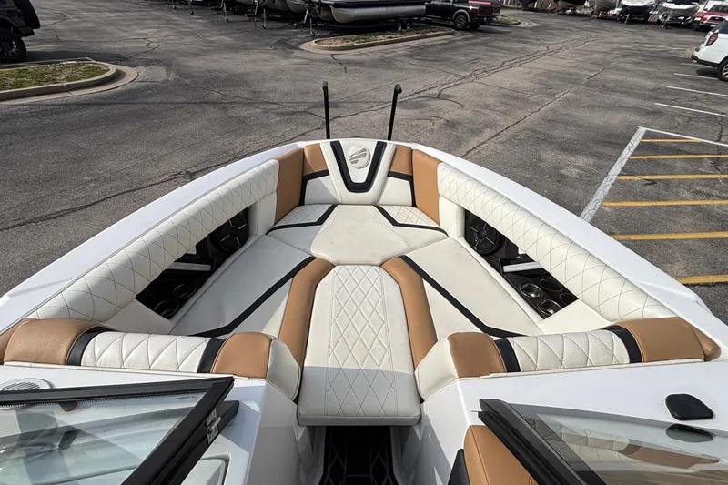 Slide: The Image of 2021 Tigé 25ZX boat interior with luxurious white and tan seating in a parking lot. - 28