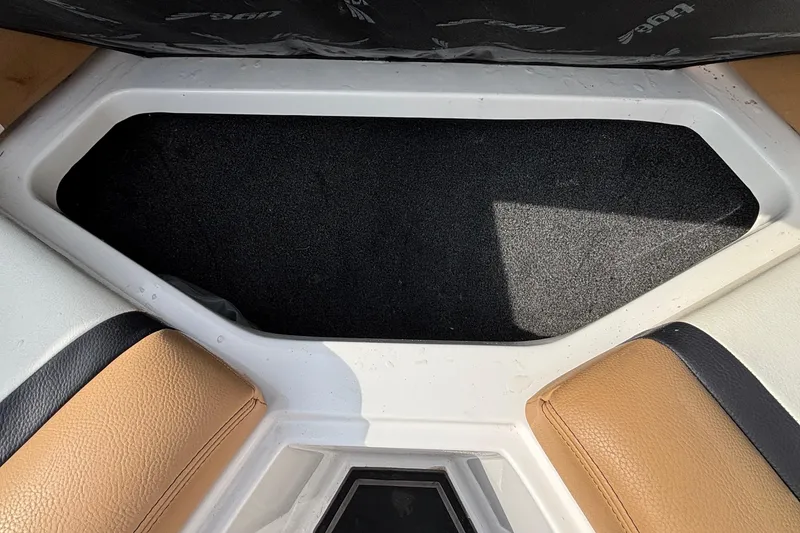Slide: The Image of 2021 Tigé 25ZX boat interior storage compartment with tan and black seating. - 33