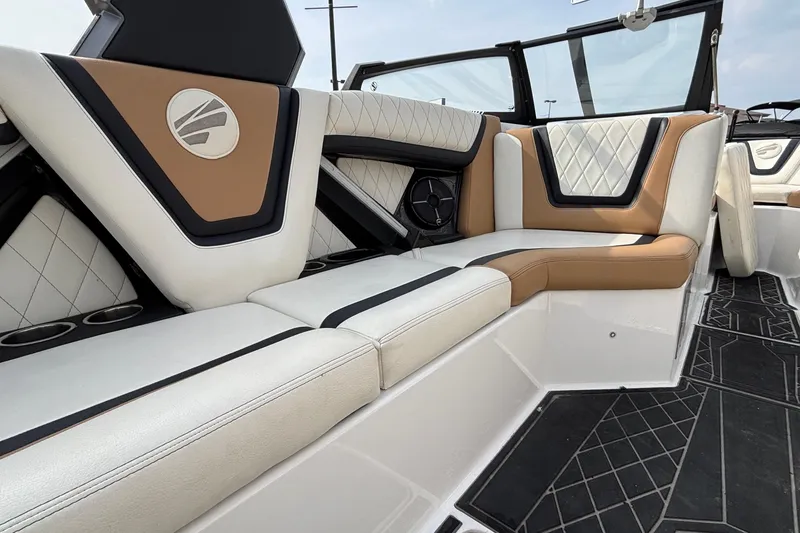 Slide: The Image of 2021 Tigé 25ZX boat interior with luxurious tan and white seating, diamond stitching, and cup holders. - 45