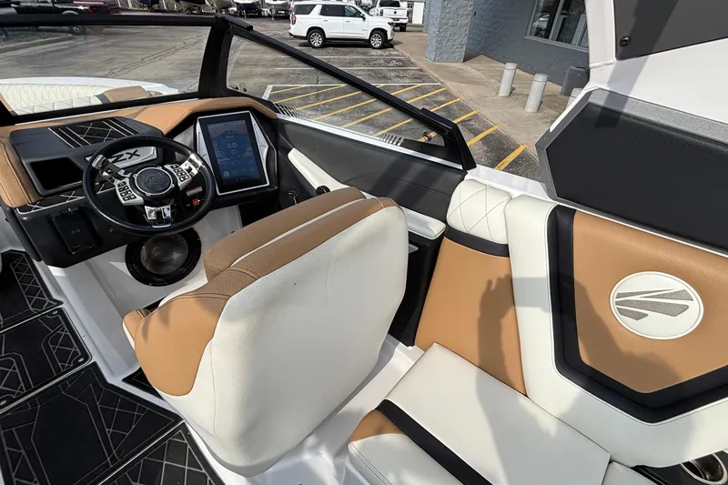 Slide: The Image of 2021 Tigé 25ZX boat interior with modern dashboard and tan leather seating. - 46