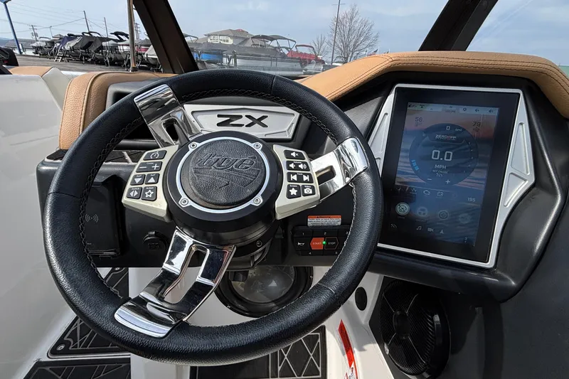 Slide: The Image of 2021 Tigé 25ZX boat dashboard with steering wheel and touchscreen display. - 48